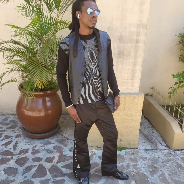 Man in a leather vest, zebra print top and studded black pants